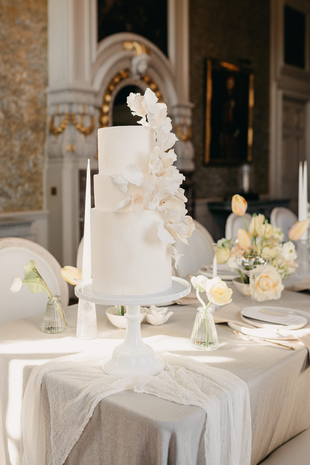 All ivory floral wedding cake on spring inspired wedding table in the blue drawing room of Stansted Park